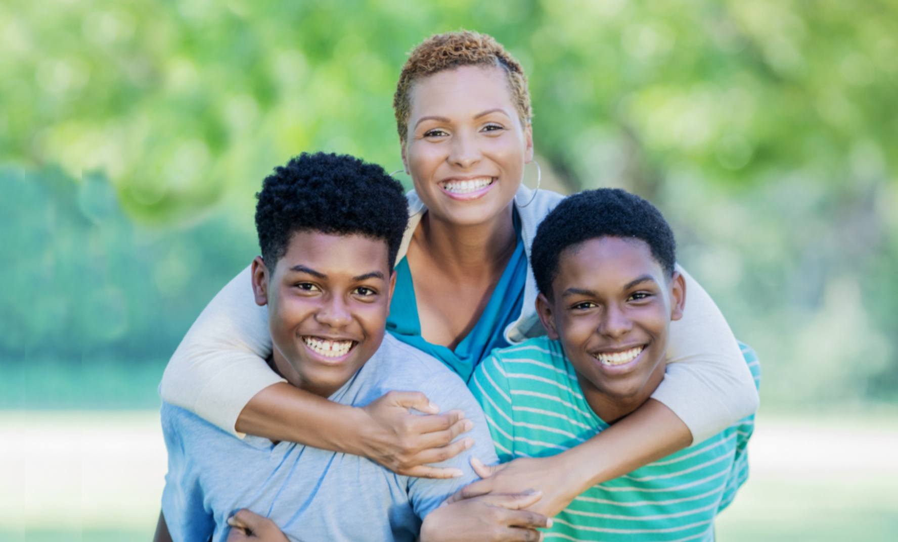 Single mom and her sons happy together in a park.