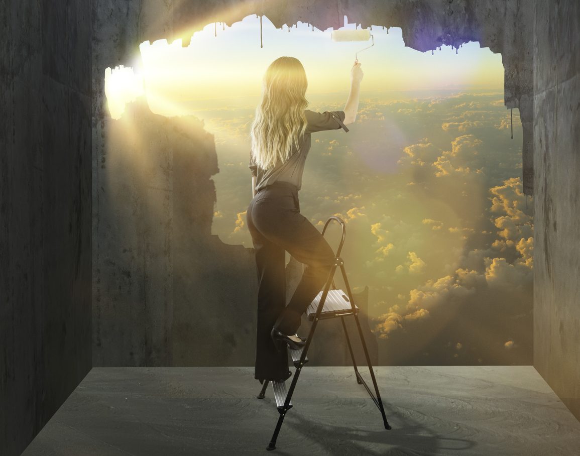 A woman breaking out of a concrete box to the beautiful world beyond.