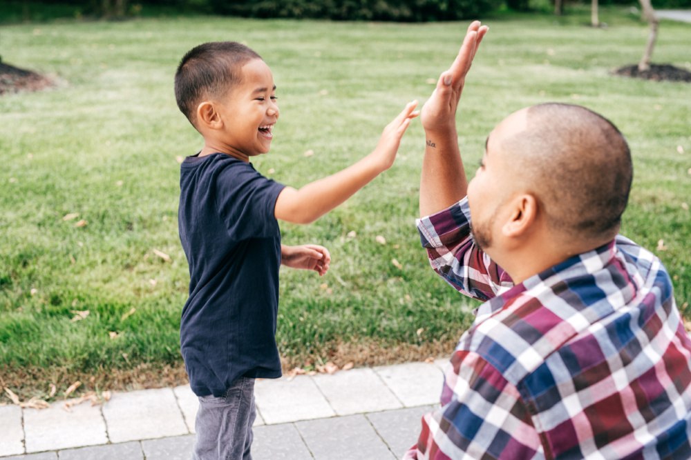 Dad and son giving each other a high five.