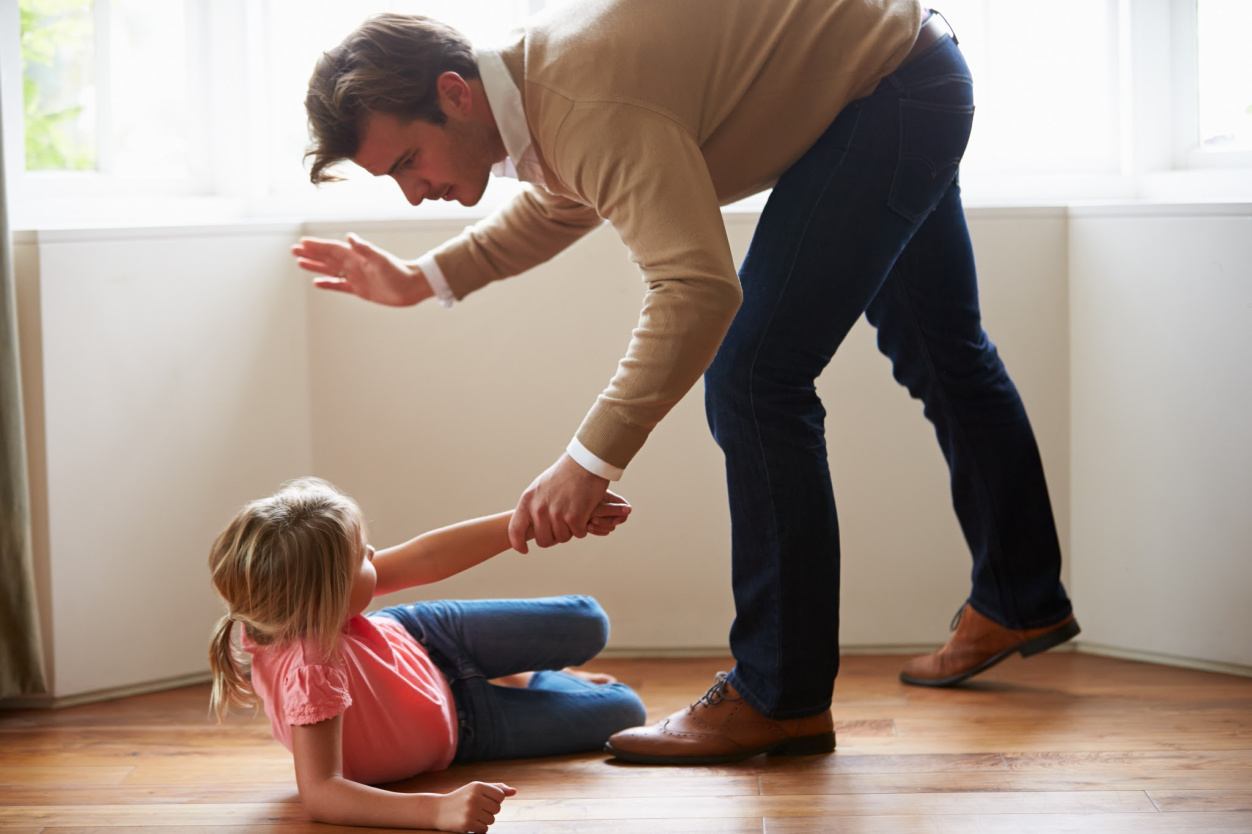 Angry father spanking his daughter.
