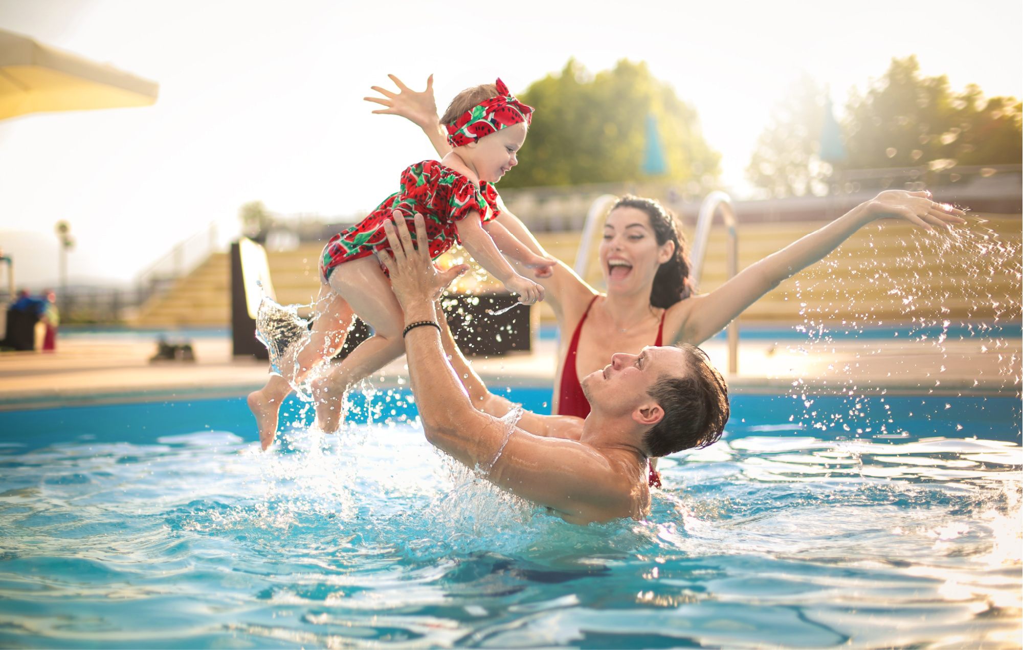 Toddler jumping from a diving board to her father.