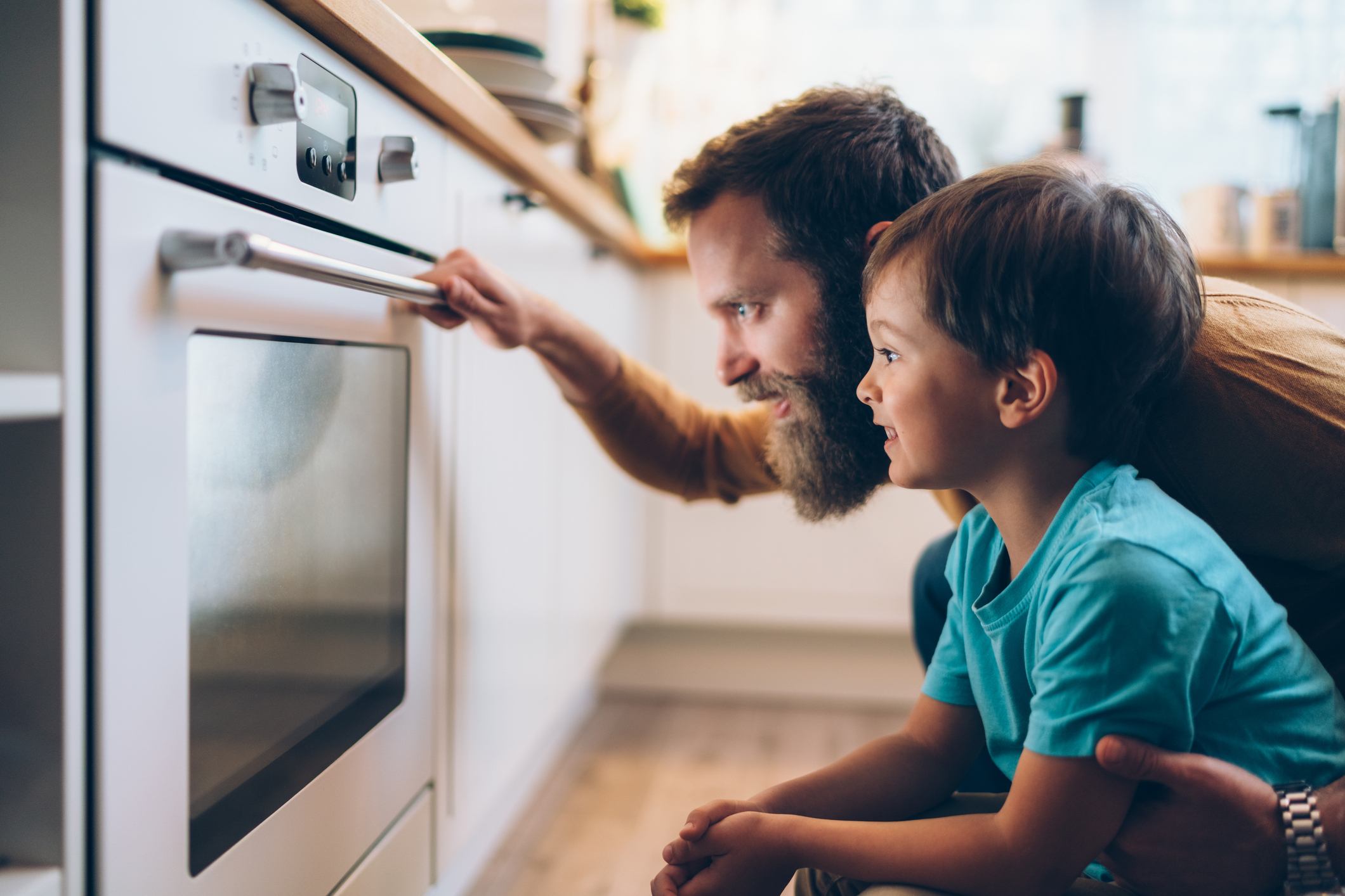 Father and son cooking dinner at home