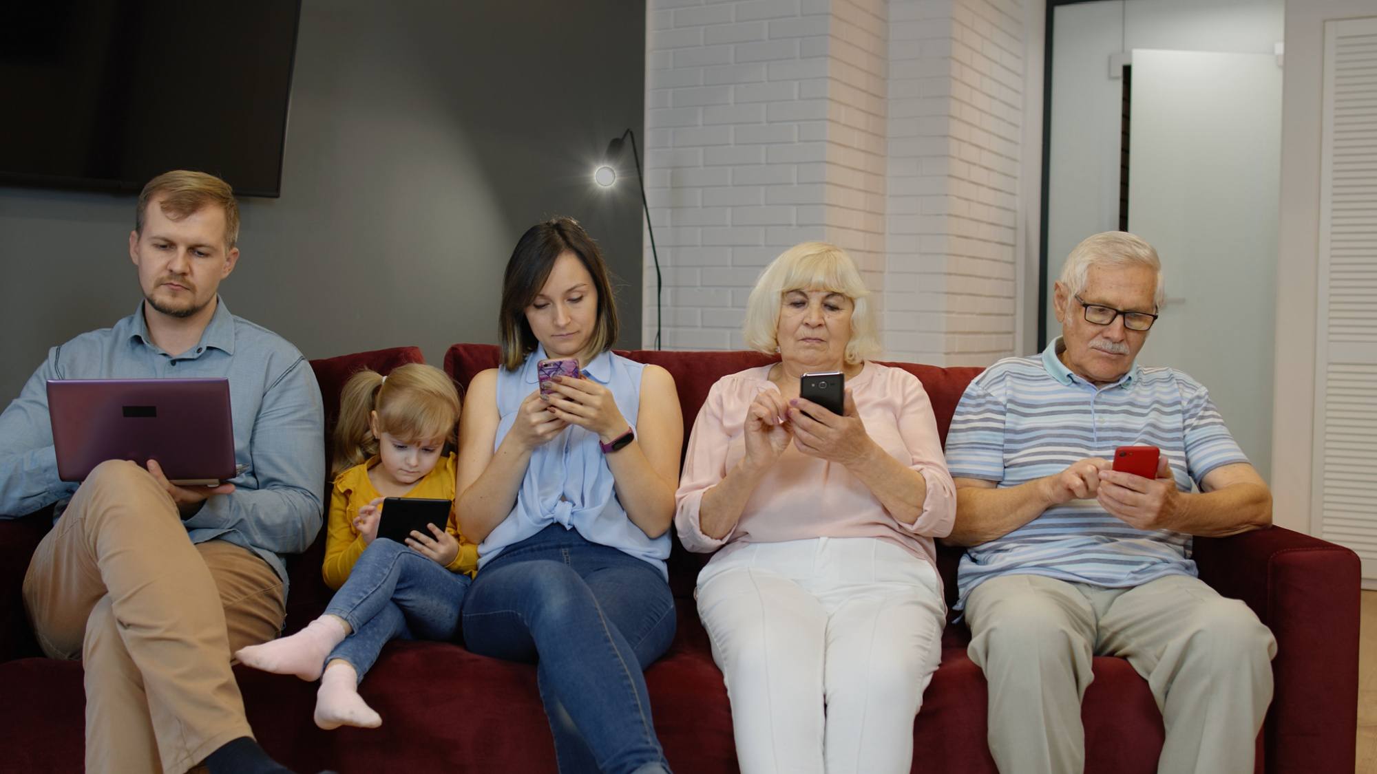 Multi generational family all absorbed in their electronic devices.