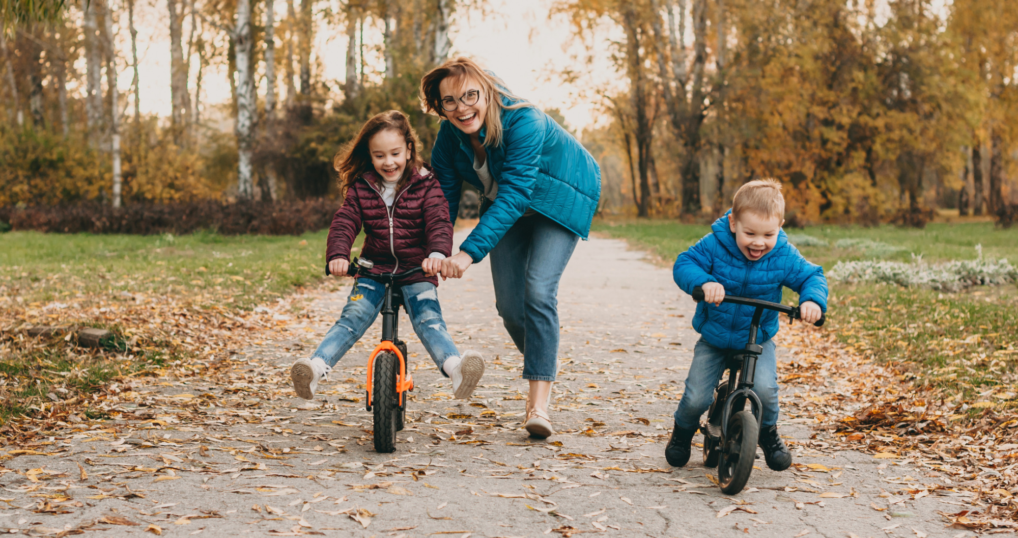 Mother teaching child how to ride a bike.